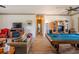 Spacious living room featuring hardwood floors, with a pool table, fireplace, and a comfortable couch at 14365 Evans Ranch Rd, Lakeland, FL 33809