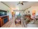 Spacious living room featuring hardwood floors, fireplace, ceiling fan, and comfortable seating arrangement at 14365 Evans Ranch Rd, Lakeland, FL 33809