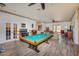 Bright living room with a pool table, neutral walls, and wood-look flooring at 14365 Evans Ranch Rd, Lakeland, FL 33809