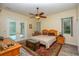 Cozy main bedroom with neutral tones, wood accents, a decorative area rug and outdoor access at 14365 Evans Ranch Rd, Lakeland, FL 33809