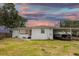 Exterior of the home with carport and boat, set against a vibrant sunset sky at 1816 W Lake Parker Dr, Lakeland, FL 33805