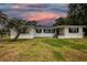 Charming single-story home with a well-maintained lawn and palm trees, under a beautiful colorful sky at 1816 W Lake Parker Dr, Lakeland, FL 33805