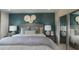 Stylish primary bedroom features a dark blue accent wall, luxurious bedding, and matching lamps at 2076 Babbling Brook Blvd, Auburndale, FL 33823