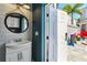 Bathroom featuring a white vanity with a round mirror and modern lighting at 7523 Excitement Dr, Kissimmee, FL 34747