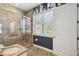 Bathroom featuring a stone shower with glass door and a window providing natural light at 7523 Excitement Dr, Kissimmee, FL 34747