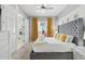 Stylish bedroom featuring a tufted headboard, yellow accents, ceiling fan, and ample natural light at 7523 Excitement Dr, Kissimmee, FL 34747