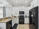 Cozy kitchen features tile floors, granite counters, black appliances, and white cabinets at 7523 Excitement Dr, Kissimmee, FL 34747