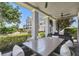 Covered patio with outdoor seating and views of the landscaped backyard and neighboring homes at 7523 Excitement Dr, Kissimmee, FL 34747