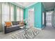Inviting sitting area with chic gray sofa, glass coffee table, and bright turquoise walls, creating a stylish space at 7523 Excitement Dr, Kissimmee, FL 34747