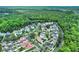 Extensive aerial view of a neighborhood surrounded by lush greenery, showcasing the landscape and many homes with red-tiled roofs at 740 Oak Shadows Rd, Kissimmee, FL 34747