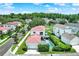 Aerial view of a white house with red tile roof, lush backyard with a pool, and manicured landscaping in a suburban community at 740 Oak Shadows Rd, Kissimmee, FL 34747