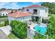 Aerial view of home with a pool and patio, white stucco and red tile roof at 740 Oak Shadows Rd, Kissimmee, FL 34747