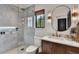 Modern bathroom featuring marble shower, updated vanity, round mirror, and tasteful decor at 740 Oak Shadows Rd, Kissimmee, FL 34747