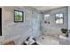 Modern bathroom with a glass shower, marble-like tile walls, and neutral tones at 740 Oak Shadows Rd, Kissimmee, FL 34747