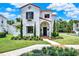 Elegant two-story stucco home with a red tile roof and manicured landscaping at 740 Oak Shadows Rd, Kissimmee, FL 34747