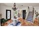 Elegant foyer features a tile floor, decorative chandelier, and staircase with patterned risers at 740 Oak Shadows Rd, Kissimmee, FL 34747