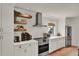 Charming kitchen features floating shelves, stainless steel appliances, and white cabinets at 740 Oak Shadows Rd, Kissimmee, FL 34747