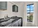 Laundry room with dark washer and dryer, overhead cabinets, and a window with a view at 740 Oak Shadows Rd, Kissimmee, FL 34747