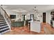 Bright living room features decorative stairs, a unique curved couch, and a kitchen with a marble counter and modern finishes at 740 Oak Shadows Rd, Kissimmee, FL 34747