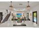 Bright living room with marble island, chandelier lighting, and staircase detail at 740 Oak Shadows Rd, Kissimmee, FL 34747