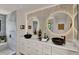 Bathroom with dual vessel sinks, lighted mirrors, and tiled walls, showcasing modern design at 740 Oak Shadows Rd, Kissimmee, FL 34747
