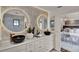 Bathroom featuring unique circular, lighted mirrors over dual vessel sinks, and elegant tile work in a modern design at 740 Oak Shadows Rd, Kissimmee, FL 34747