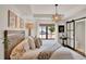 Bright bedroom featuring tray ceiling, pendant lighting and a large window overlooking mature trees at 740 Oak Shadows Rd, Kissimmee, FL 34747