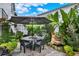 Outdoor dining area with a large umbrella, water feature, lush landscaping, and ambient string lights at 740 Oak Shadows Rd, Kissimmee, FL 34747