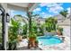 Lush backyard pool area with potted plants, stone pavers, and a clear blue pool under a bright sky at 740 Oak Shadows Rd, Kissimmee, FL 34747