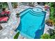 Inviting pool with baja shelf, waterfall feature, and stone pavers at 740 Oak Shadows Rd, Kissimmee, FL 34747