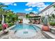 Backyard pool with tiled edge, patio chairs, privacy fence, and a sunbathing area at 740 Oak Shadows Rd, Kissimmee, FL 34747