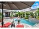 Inviting backyard pool area with lounge chairs, dining set and lush tropical landscaping at 740 Oak Shadows Rd, Kissimmee, FL 34747