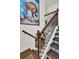 Staircase with decorative tiles, black wrought iron railing, and colorful artwork at 740 Oak Shadows Rd, Kissimmee, FL 34747