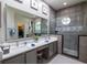Modern bathroom featuring double sinks, tile floors, and a walk-in shower at 790 Country Charm Cir, Oviedo, FL 32765