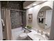 Updated bathroom featuring a tub with decorative tile surround, modern vanity, and a round decorative mirror at 790 Country Charm Cir, Oviedo, FL 32765