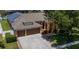 Stunning home featuring a three-car garage, turret entrance, manicured landscaping, and a paver walkway at 790 Country Charm Cir, Oviedo, FL 32765