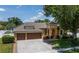 Stunning home featuring a three-car garage, turret entrance, manicured landscaping, and a paver walkway at 790 Country Charm Cir, Oviedo, FL 32765
