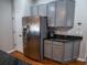 Kitchen showcasing stainless steel refrigerator, gray cabinets, dark granite countertops, and wood-look flooring at 790 Country Charm Cir, Oviedo, FL 32765