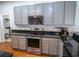 Kitchen with gray cabinets, dark granite countertops, and stainless steel oven and microwave at 790 Country Charm Cir, Oviedo, FL 32765