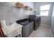 Bright laundry room with modern washer and dryer, granite countertop, storage, and window providing natural light at 790 Country Charm Cir, Oviedo, FL 32765
