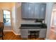Home office nook with built-in gray cabinets, dark granite countertop, and wood-look flooring at 790 Country Charm Cir, Oviedo, FL 32765