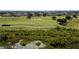 Scenic aerial view of a lush green golf course lined with well-maintained landscaping and serene water features at 1430 Reunion Blvd, Reunion, FL 34747