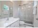 Bright bathroom featuring a vanity with quartz countertops, framed mirror, and large glass-enclosed shower at 1430 Reunion Blvd, Reunion, FL 34747