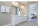 This bathroom features double sinks with white cabinets and a view into the bedroom at 1430 Reunion Blvd, Reunion, FL 34747