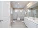 Modern bathroom with double sinks, white cabinets, and a large glass-enclosed shower at 1430 Reunion Blvd, Reunion, FL 34747