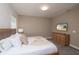 Modern bedroom featuring a queen bed, dresser, and wall-mounted TV, creating a cozy and functional living space at 1430 Reunion Blvd, Reunion, FL 34747