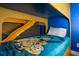 Close-up of custom bunk beds with blue minion themed bedspreads and yellow slide at 1430 Reunion Blvd, Reunion, FL 34747