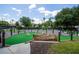 Community putting green with artifical grass, stone accents and manicured landscaping at 1430 Reunion Blvd, Reunion, FL 34747