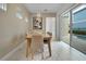 Bright dining room with a wooden table, seating for six, and access to the outdoor pool area at 1430 Reunion Blvd, Reunion, FL 34747