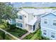 View of a charming two-story home with pastel exterior, shutters, and manicured landscaping at 1430 Reunion Blvd, Reunion, FL 34747